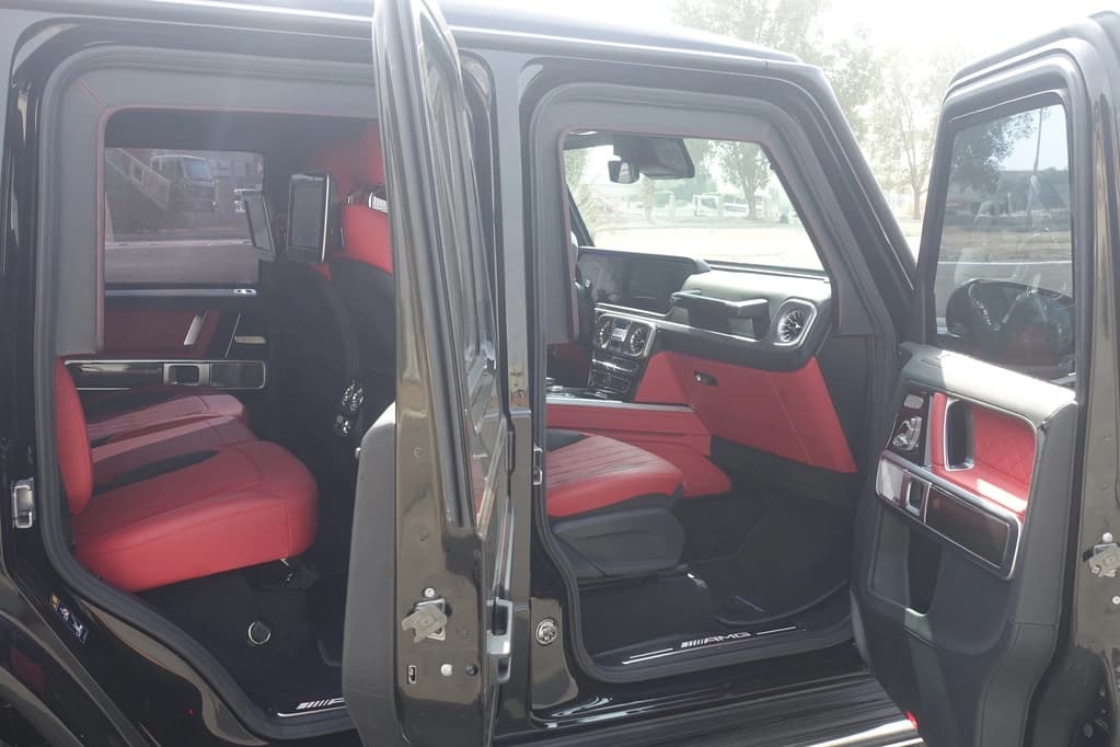 Mercedes-Benz G63 AMG سوداء مصفحة من اليسار مع كل الأبواب مفتوحة