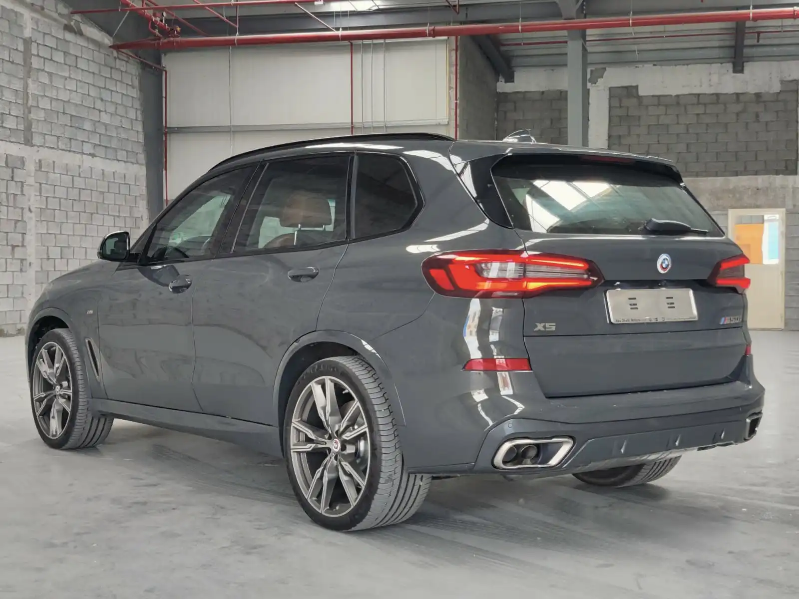 BMW X5 M50i grey armored luxury SUV rear left exterior angle