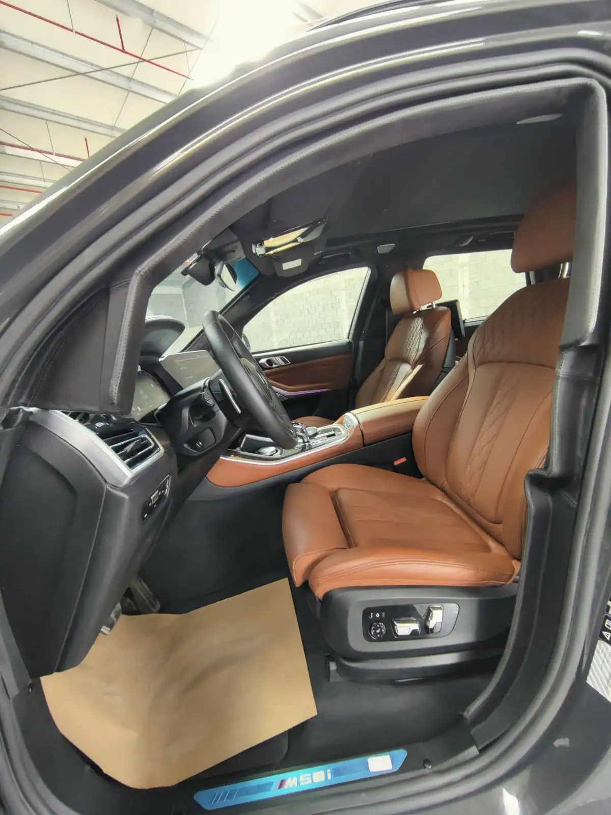 BMW X5 M50i grey armored luxury SUV driver door open view