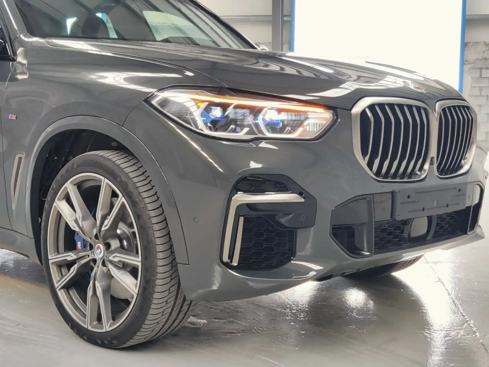 BMW X5 M50i grey armored luxury SUV front left light detail