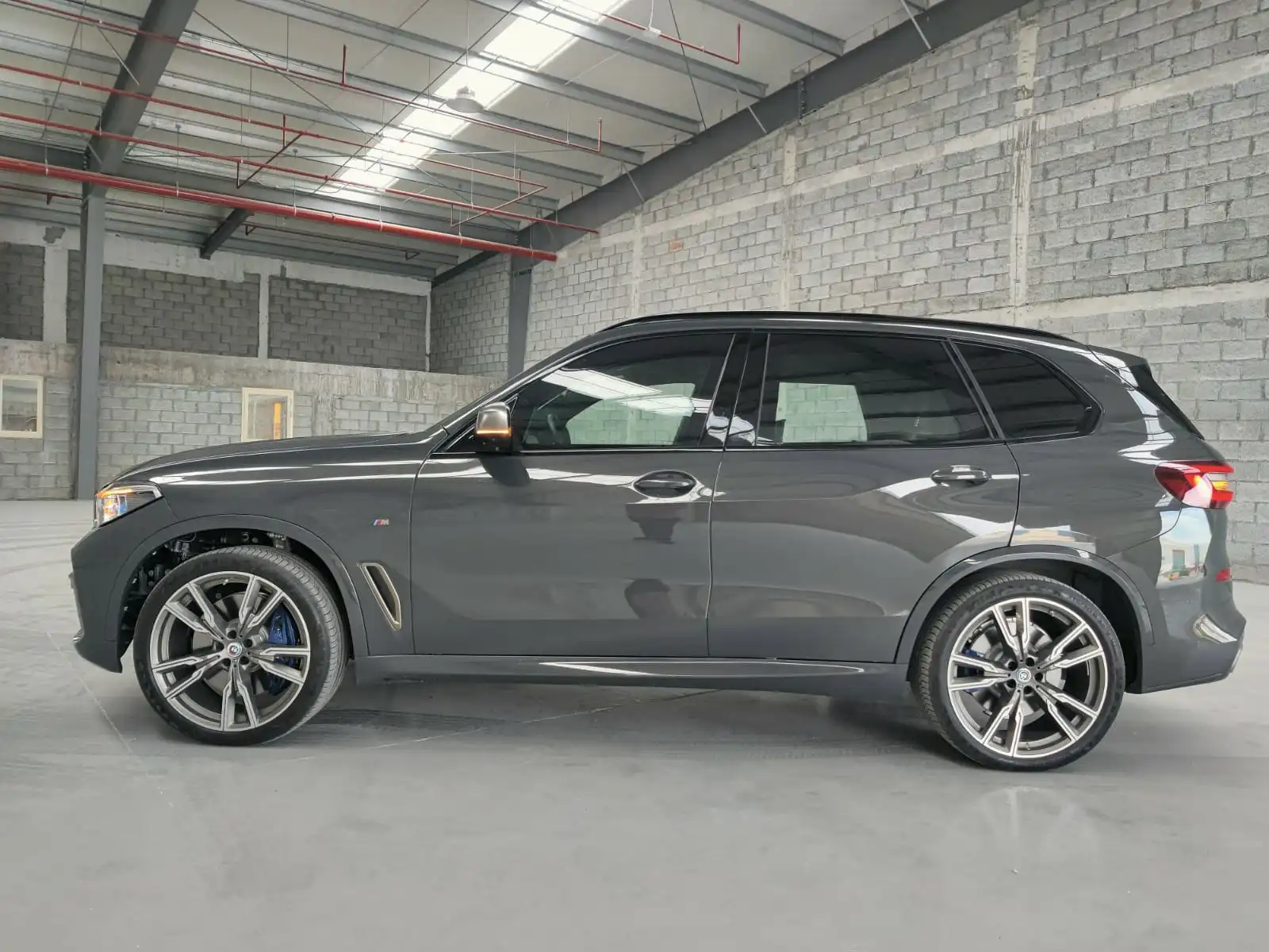 BMW X5 M50i grey armored luxury SUV full left side view