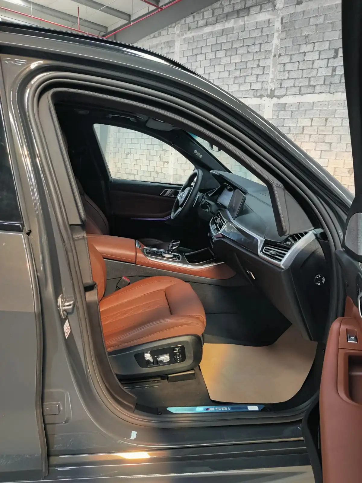 BMW X5 M50i رمادية مصفحة مع باب الراكب مفتوح