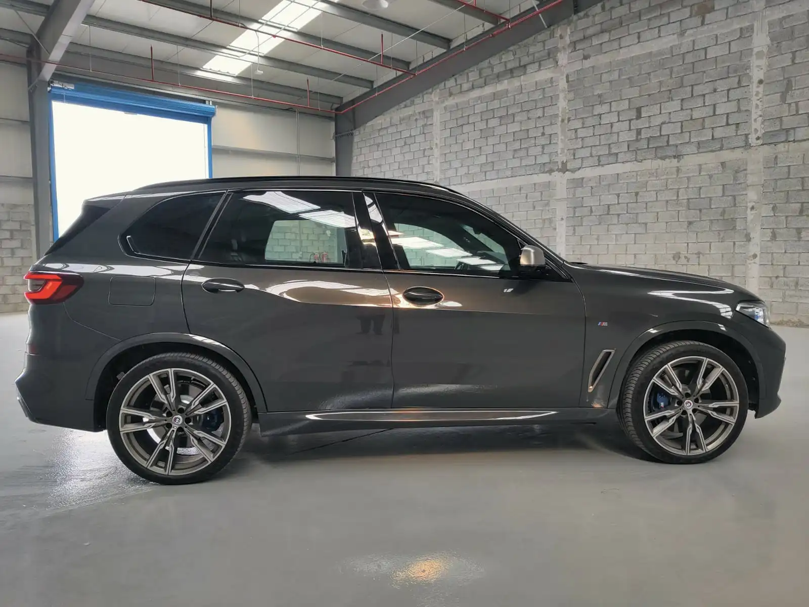 BMW X5 M50i grey armored luxury SUV right side exterior view
