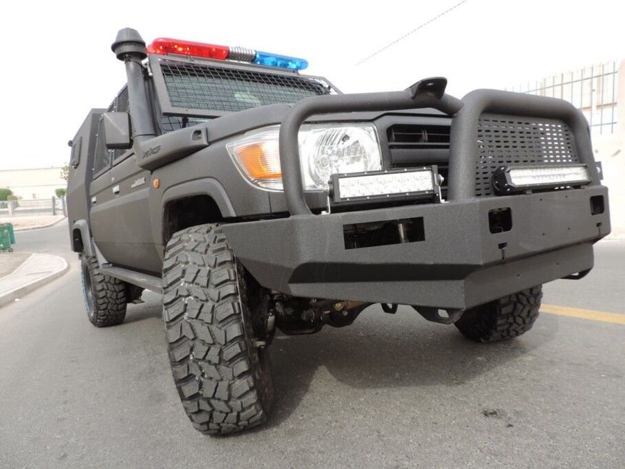 Front view of tactical LC79 with police lights and protective grill
