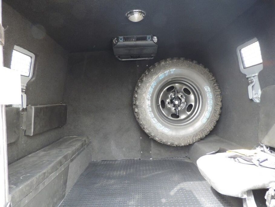 Interior cargo compartment with spare tire mount in armored LC79