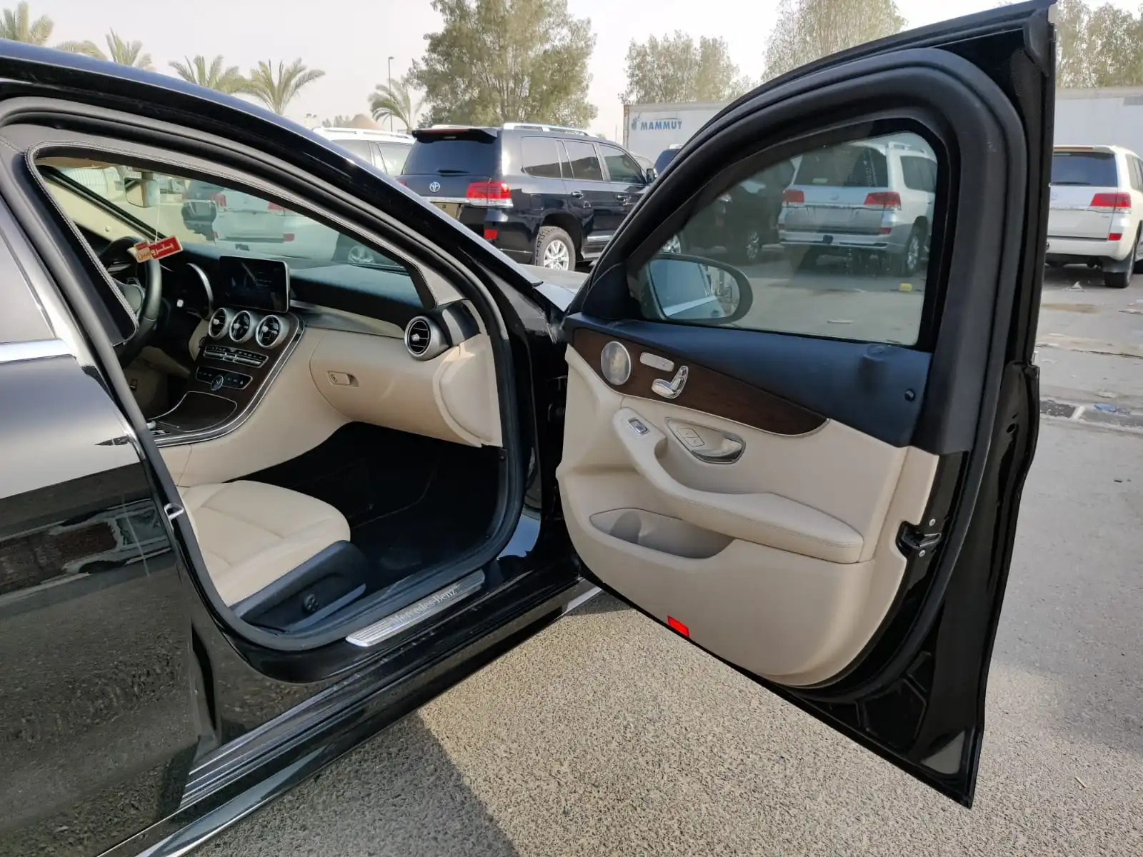 Mercedes-Benz C300 سوداء مصفحة مع باب الراكب الأمامي مفتوح