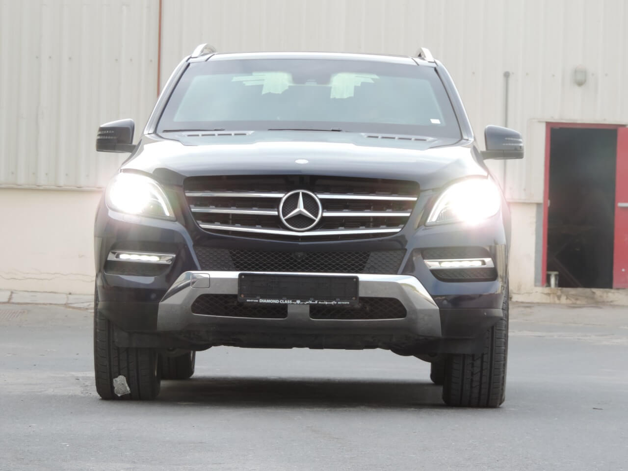 Mercedes-Benz ML 400 زرقاء مصفحة بمنظر أمامي مع الإضاءة