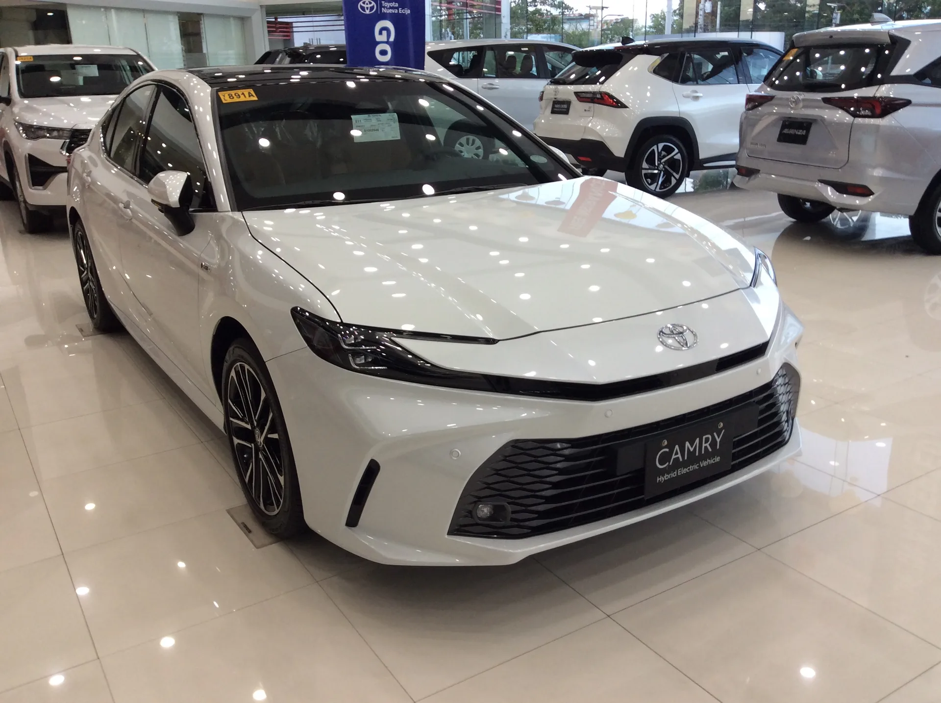 White current-generation Toyota Camry shown from the front left