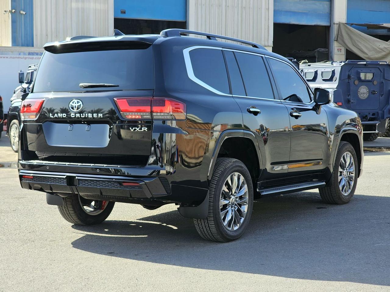 Toyota Land Cruiser 300 VXR مصفحة من الخلف بزاوية مع هيكل أسود