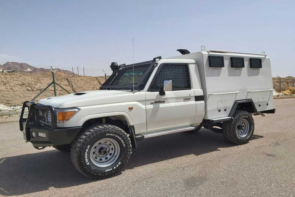 Toyota Land Cruiser 70 Series security transport vehicle featuring reinforced mesh window protection