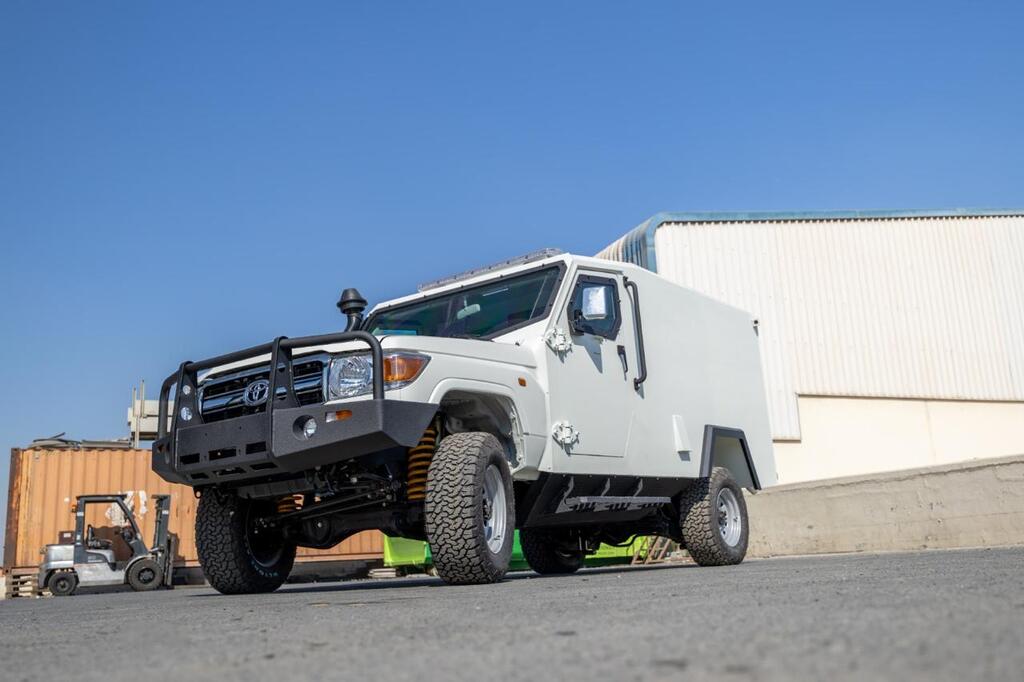 Toyota Land Cruiser 79 with custom reinforced front bumper at industrial site